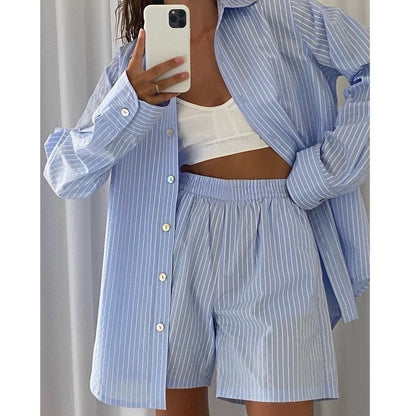 Frau in blau-weiß gestreiftem Pyjama-Set, Hemd und Shorts, Selfie im Spiegel.