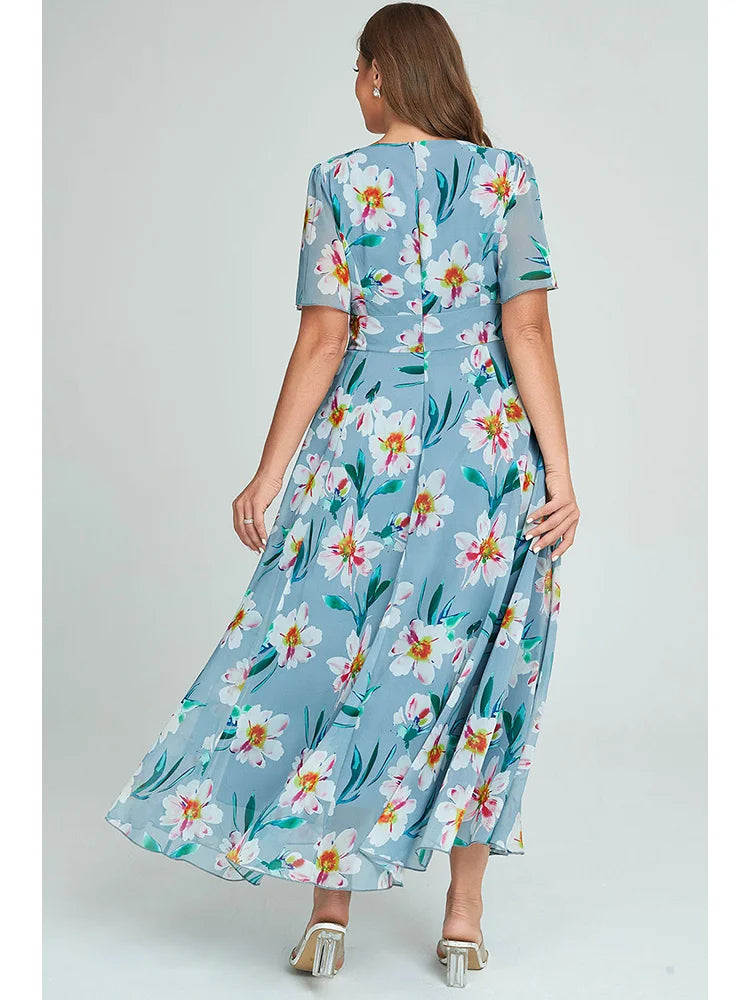 Frau in blauem, geblümtem Maxikleid aus Chiffon, Rückansicht, Sommermode, elegant.