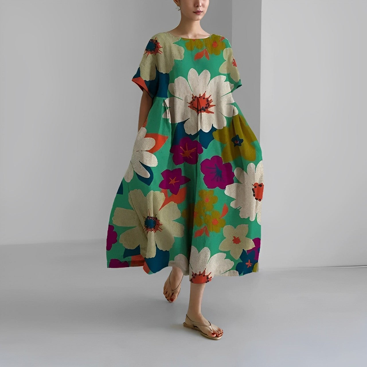 Frau in grüner, geblümter, knöchellanger Freizeitkleid mit kurzen Ärmeln und Rundhalsausschnitt.