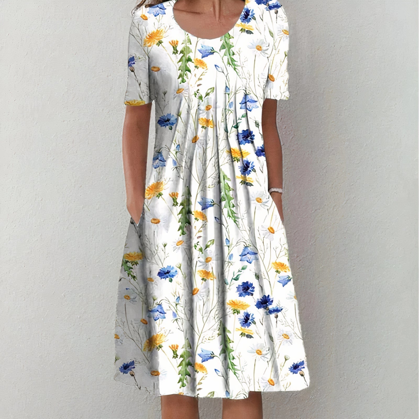 Frau in weißem Sommerkleid mit buntem Blumenmuster, knielang, kurzärmelig.