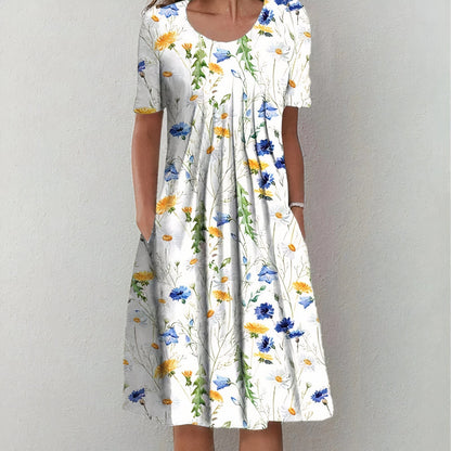 Frau in weißem Sommerkleid mit buntem Blumenmuster, knielang, kurzärmelig.