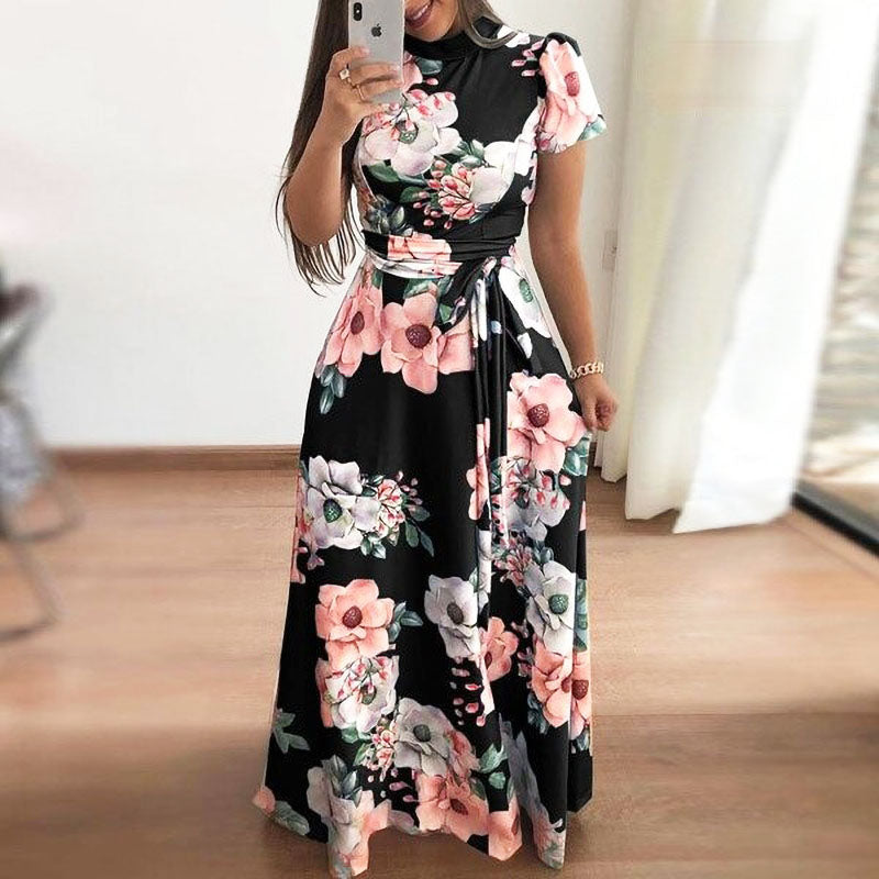 Frau in langem, schwarzem Blumenkleid mit rosa und weißen Blumenmuster, Sommermode.