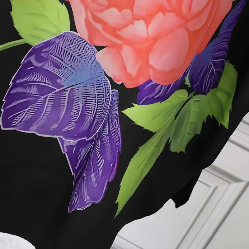 Schwarzes Kleid mit rosa Blumenmuster, lila Blättern, elegantes Design, Damenmode.