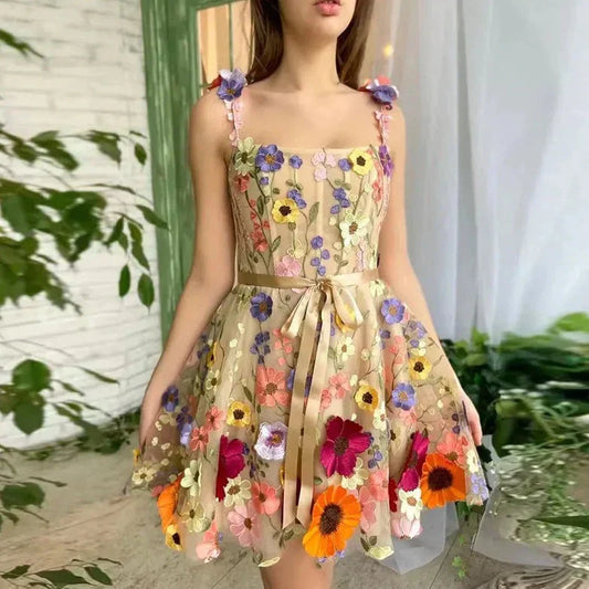 Frau in einem geblümten, ärmellosen Kleid mit Schleife, Sommermode, bunte Blumenstickerei.