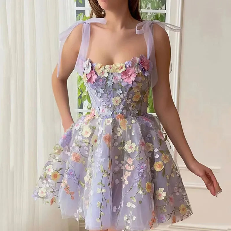 Frau in lila Blumenkleid, ärmellos, mit Schleifen, ideal für Sommermode und Partys.