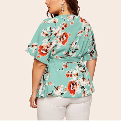 Frau in blauer, geblümter Bluse mit Gürtel, Rückansicht, modisch, elegant, Sommerkleidung.