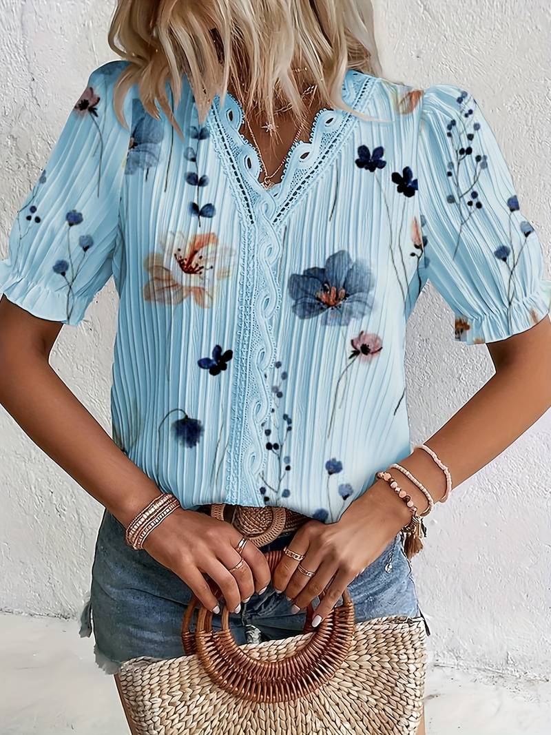 Frau in blauer Blumenbluse mit Spitzenkragen, Jeansshorts, Strohtasche, Sommermode.