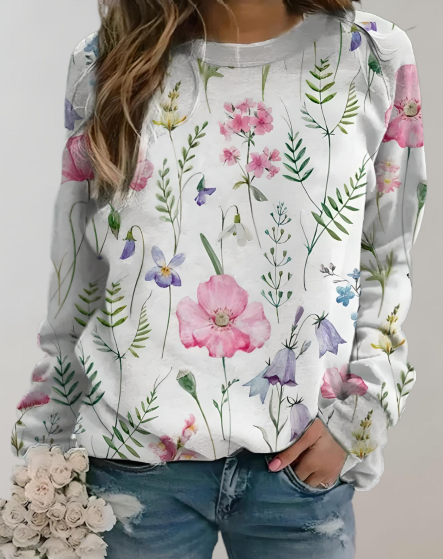 Frau in weißem Blumenpullover, Jeans, hält Blumenstrauß, modisch, lässig, Frühlingslook.