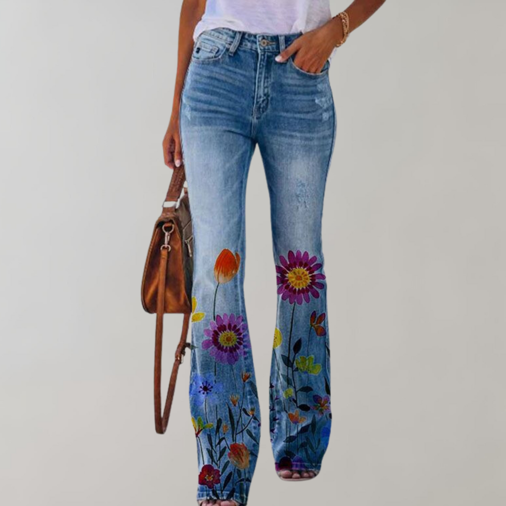 Frau in blauer Jeans mit Blumenmuster, weißem T-Shirt und brauner Tasche.