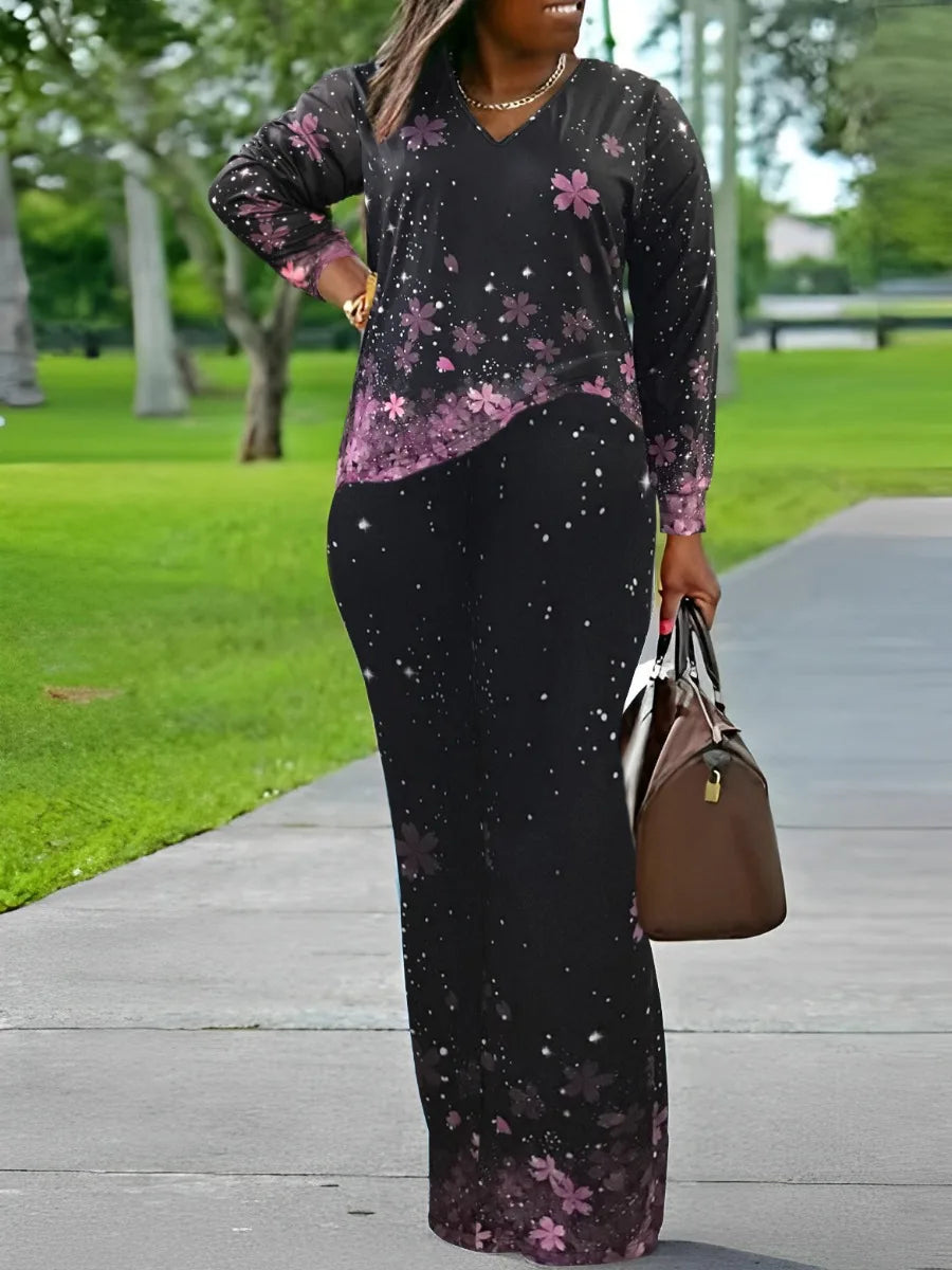 Frau in schwarzem Blumen-Jumpsuit mit Handtasche im Park, modische Damenbekleidung.