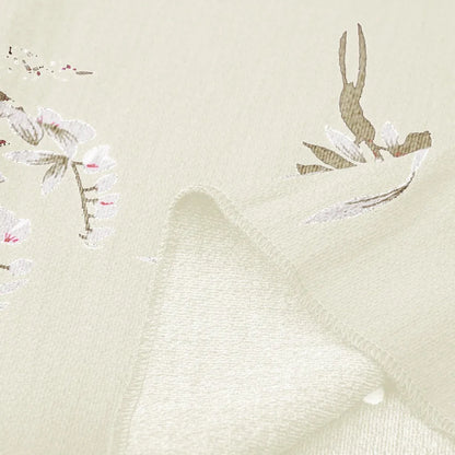 Beige Stoff mit floralen Mustern, weiche Textur, ideal für Bekleidung und Dekoration.