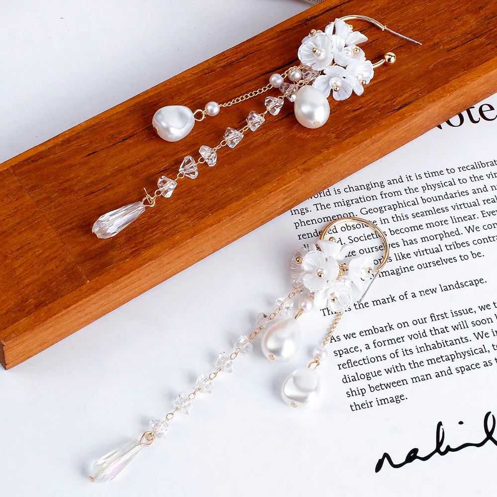 Lange Ohrringe mit weißen Perlen und Blumen, eleganter Schmuck, Damenaccessoire.