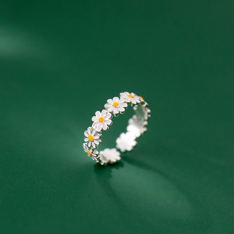 Silberner Gänseblümchen-Ring, Blumenmuster, Damen-Schmuck, modisch, auf grünem Hintergrund.
