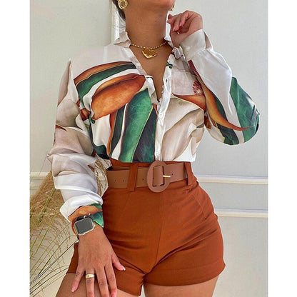 Frau in weißer Bluse mit Blattmuster und braunen Shorts, modisch, elegant, Sommeroutfit.