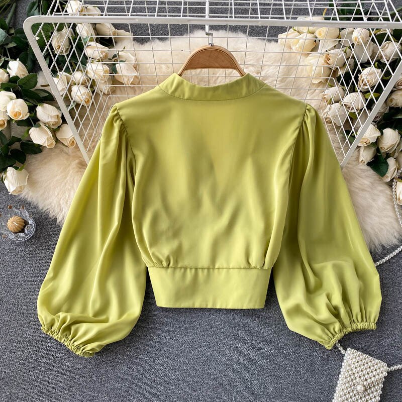 Grüne Satinbluse mit Puffärmeln, elegantes Design, Damenmode, Rückansicht.