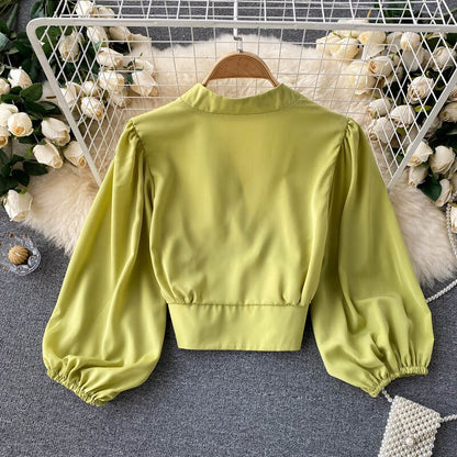 Grüne Satinbluse mit Puffärmeln, elegantes Design, Damenmode, Rückansicht.