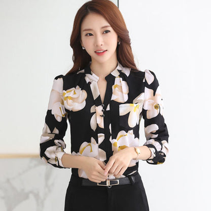 Frau in schwarzer Bluse mit Blumenmuster, elegant, Büro-Outfit, Damenmode, Langarm, modern.