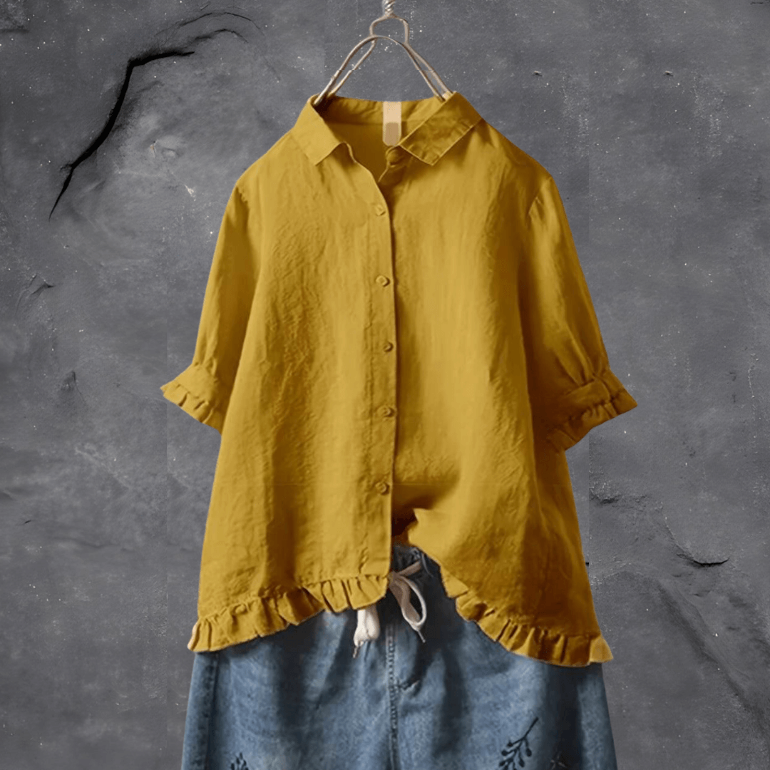Gelbe Leinenbluse mit Rüschen, Damenmode, lässig, Sommer, auf grauem Hintergrund.