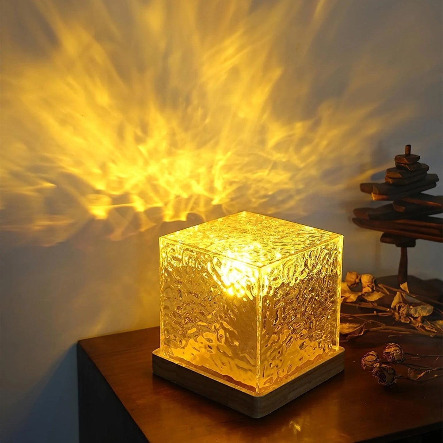Leuchtende Würfellampe aus Glas auf Holztisch, warmes gelbes Licht, dekorative Beleuchtung.
