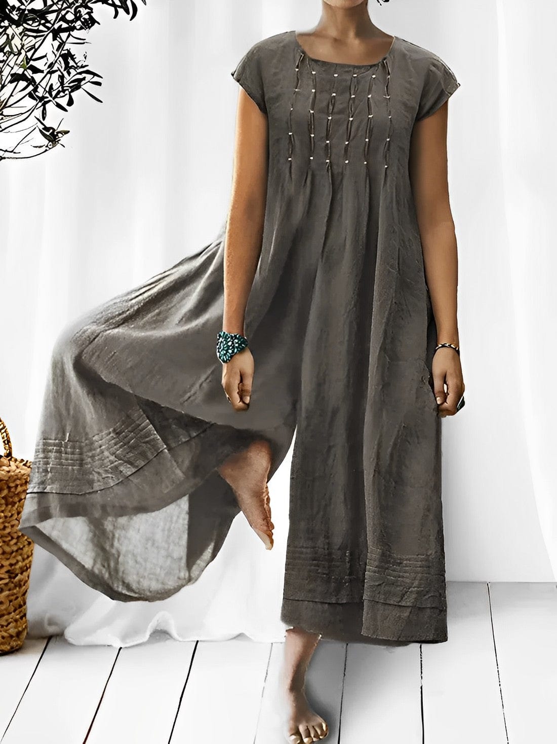 Frau trägt grauen Boho-Jumpsuit aus Leinen, modisch, ärmellos, Sommermode, elegant.