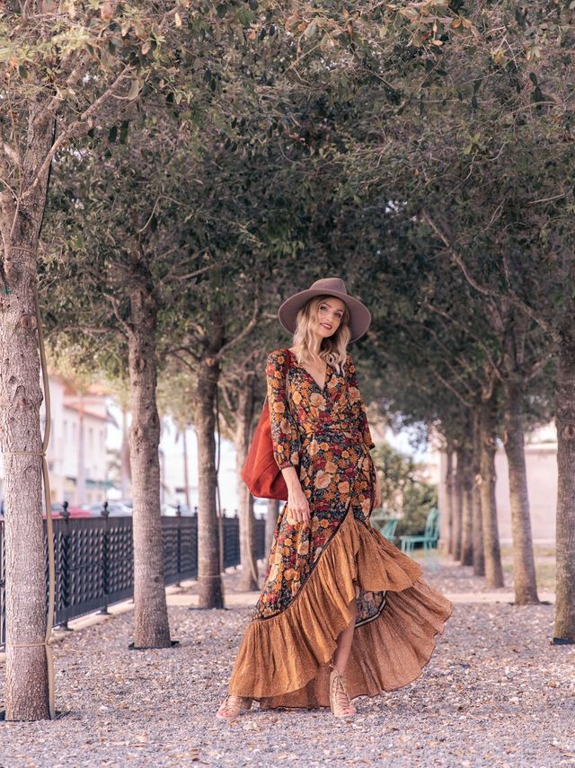 Frau in langem, geblümtem Kleid und Hut, Herbstmode, Spaziergang im Park, stilvoll, elegant.