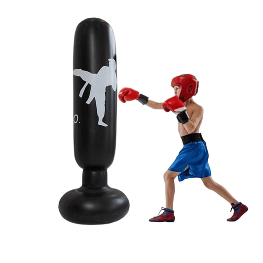 Junge boxt gegen schwarzen Standboxsack, Boxausrüstung, Sporttraining, roter Helm.