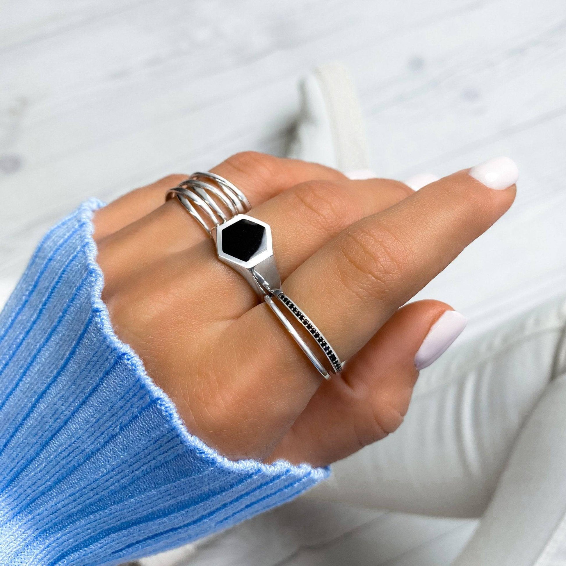 Silberring mit schwarzem Sechseck-Design, Damenmode, eleganter Schmuck, Hand, Nahaufnahme.