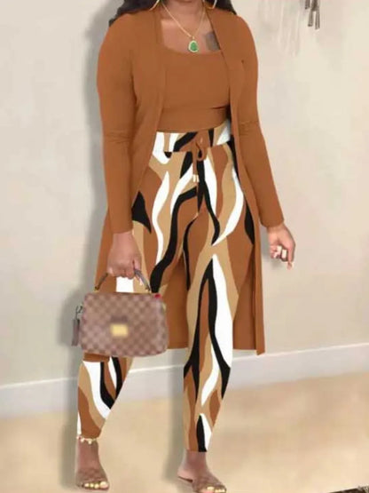 Frau in braunem Cardigan, gemusterter Hose, hält karierte Handtasche, modisches Outfit.