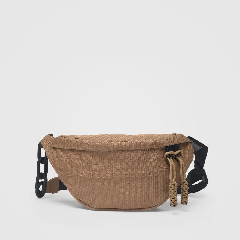 Braune Gürteltasche aus Stoff mit schwarzem Riemen und Kordelzug, modisches Accessoire.