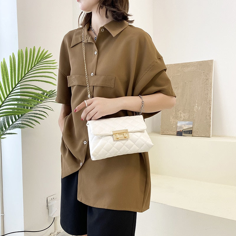 Frau mit brauner Bluse und weißer gesteppter Umhängetasche aus Leder, modern und elegant.