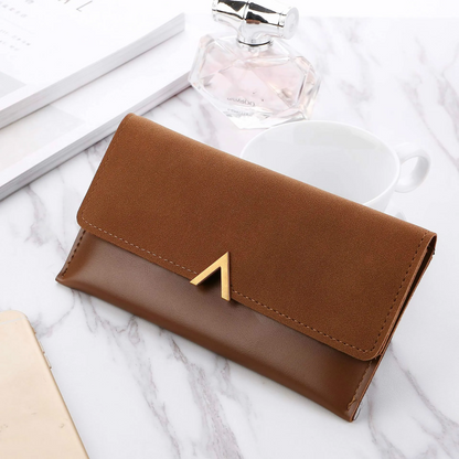 Braune Lederhandtasche auf Marmortisch mit Kaffeetasse und Parfümflasche im Hintergrund.