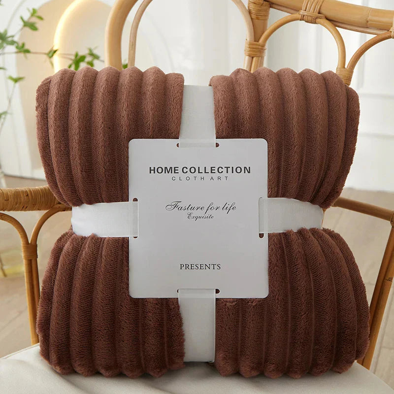 Braune, gerippte Decke aus Fleece, Home Collection, auf Rattan-Stuhl, gemütlich, dekorativ.