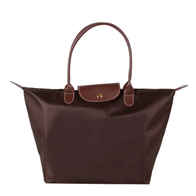 Braune Damenhandtasche aus Leder und Nylon, elegant, mit Tragegriffen und Druckknopfverschluss.