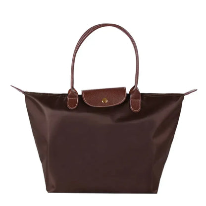 Braune Damenhandtasche aus Leder und Nylon, elegant, mit Tragegriffen und Druckknopfverschluss.