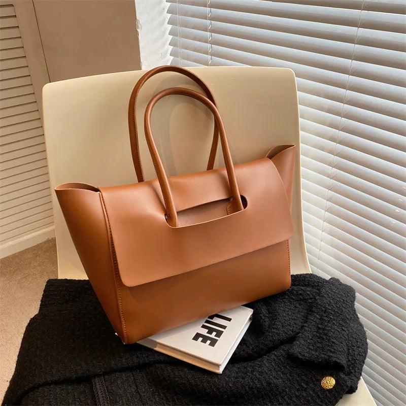 Braune Ledertasche auf Stuhl, modernes Design, Damenhandtasche, stilvoll, elegant, Accessoire.