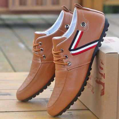 Braune Herrenschuhe aus Leder mit Schnürung und sportlichem Design auf Holzboden.