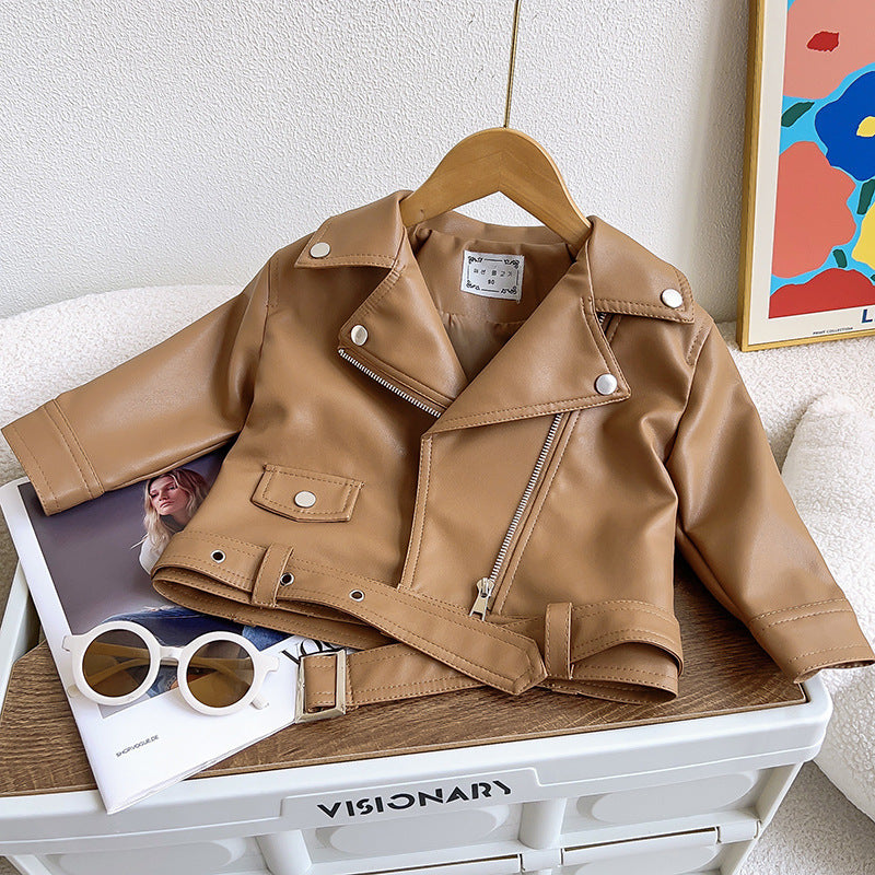 Braune Lederjacke für Kinder, Reißverschluss, Gürtel, modisch, auf Holzstuhl drapiert.