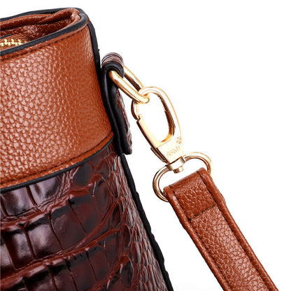 Braune Lederhandtasche mit Krokodilleder-Optik und goldener Metallschnalle.