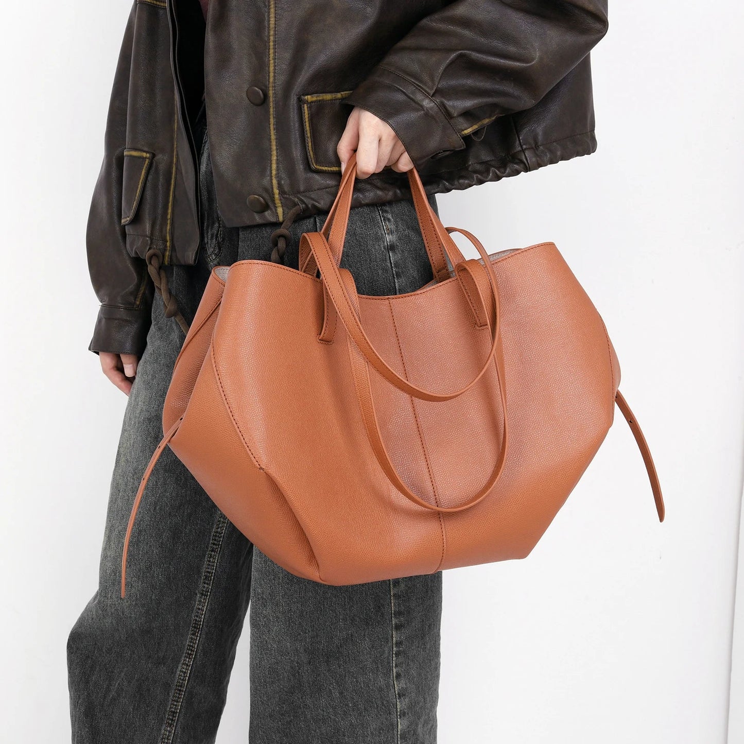 Frau mit brauner Ledertasche, lässiger Stil, Damenmode, große Handtasche, Alltagsgebrauch.