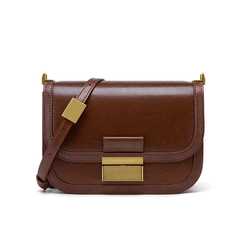 Braune Lederhandtasche mit goldenen Details, Umhängegurt, elegantes Design, Damenmode.