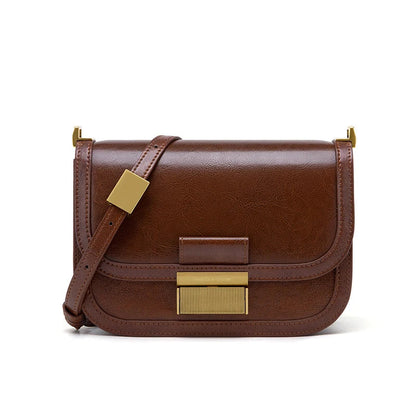 Braune Lederhandtasche mit goldenen Details, Umhängegurt, elegantes Design, Damenmode.