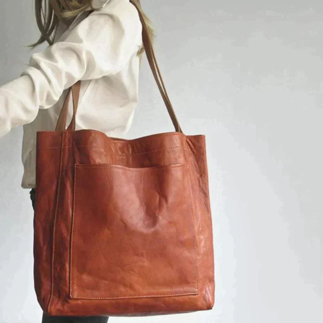 Frau mit großer brauner Ledertasche, modisches Accessoire, elegantes Design, Alltagstasche.
