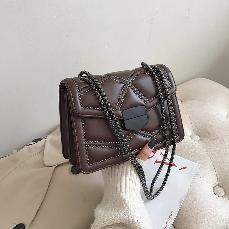Braune Lederhandtasche mit Kettenriemen, gesteppte Details, modisch, elegant, Damenaccessoire.