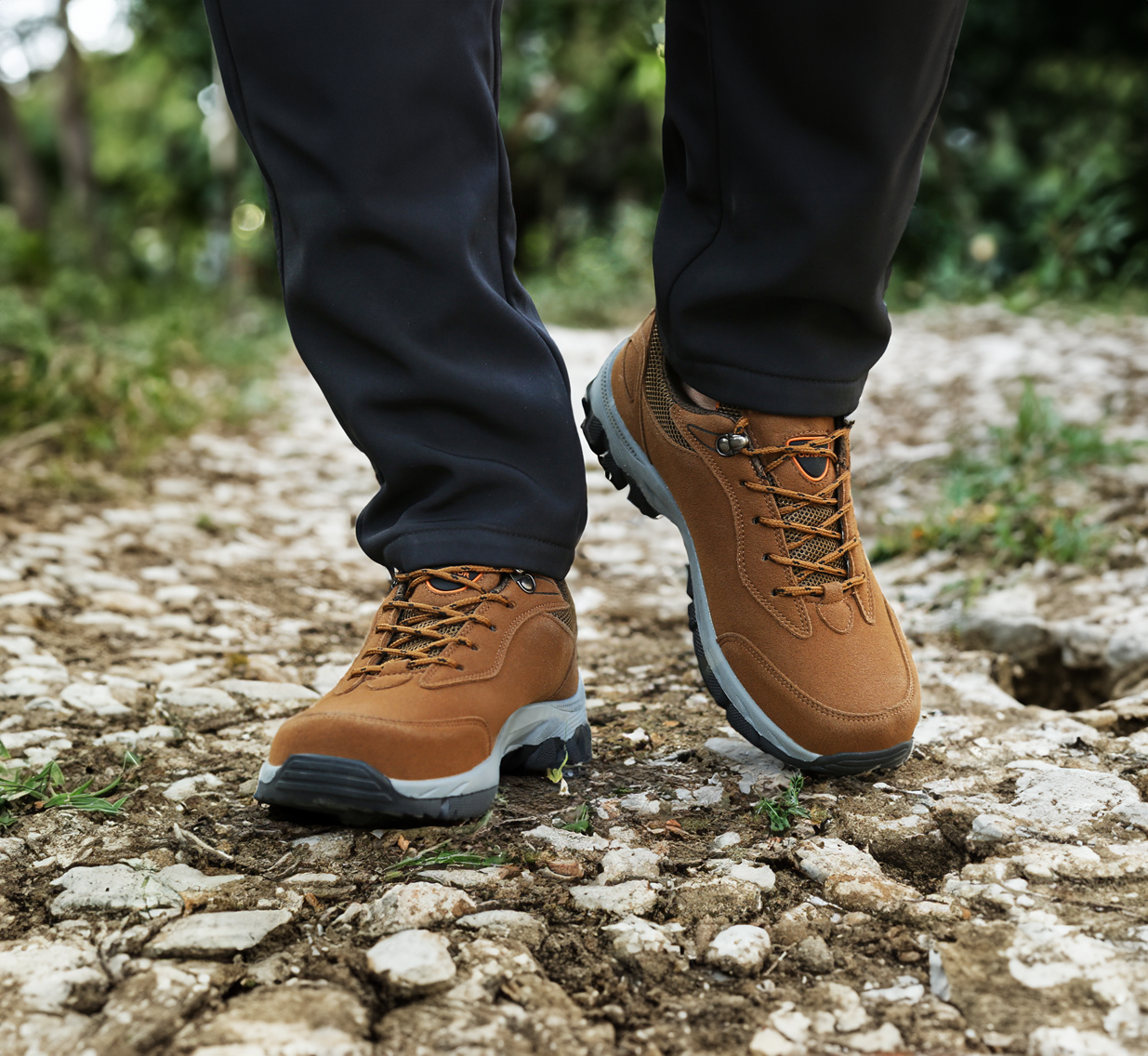 Braune Wanderschuhe aus Leder auf steinigem Weg, Outdoor-Aktivität, robuste Sohlen.