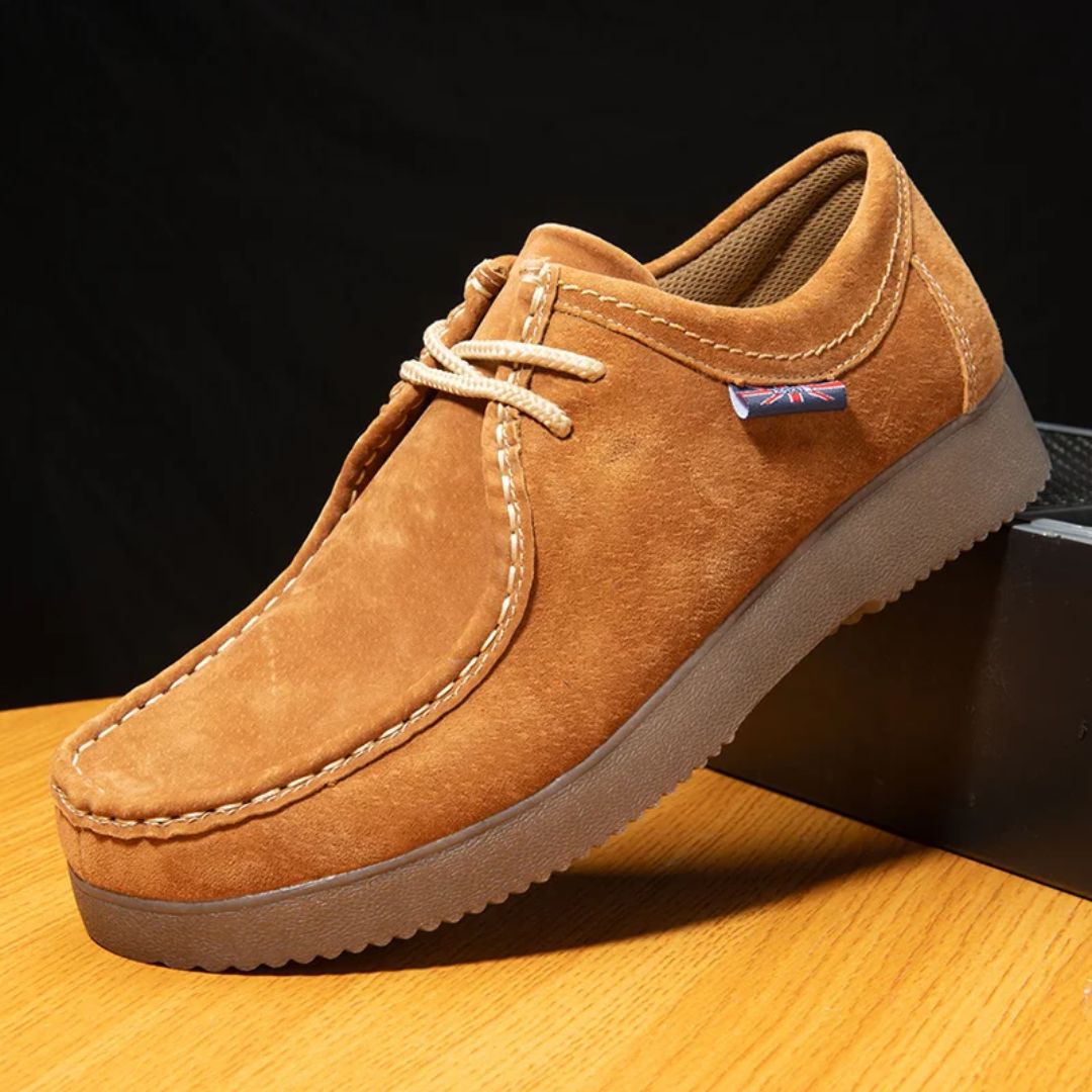 Brauner Wildleder-Herrenschuh, rutschfeste Sohle, lässig, bequem, modisch, auf Holztisch.