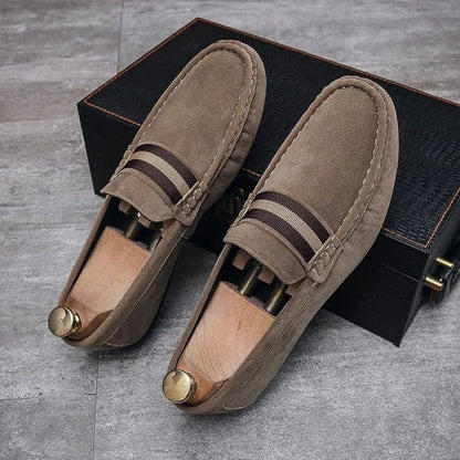 Braune Wildleder-Loafer mit Holzschuhspanner auf grauem Boden, elegante Herrenschuhe.