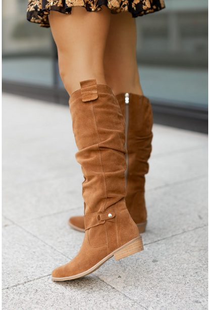 Braune Wildlederstiefel für Damen, kniehoch, modisch, Herbstmode, Straßenhintergrund.