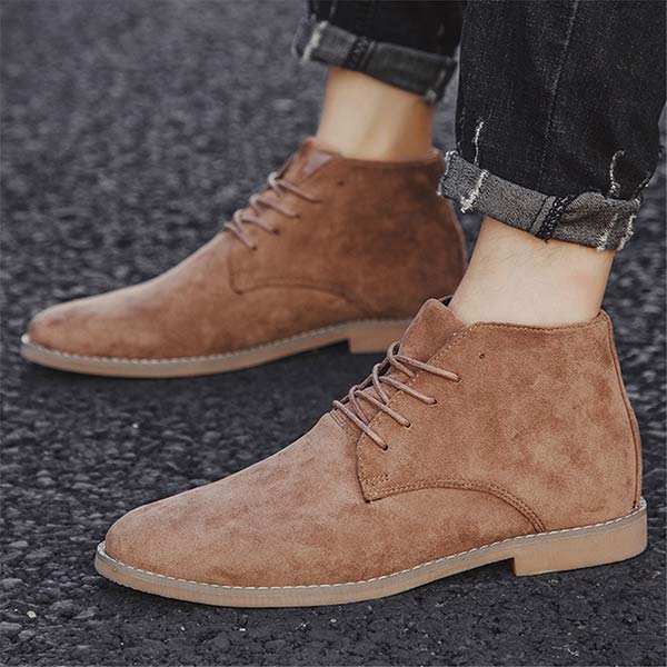 Braune Wildlederstiefel für Herren, lässig, knöchelhoch, mit Schnürung, auf Asphalt.