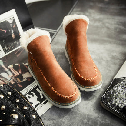 Braune Wildleder-Winterstiefel mit weißem Fellfutter auf grauem Hintergrund.