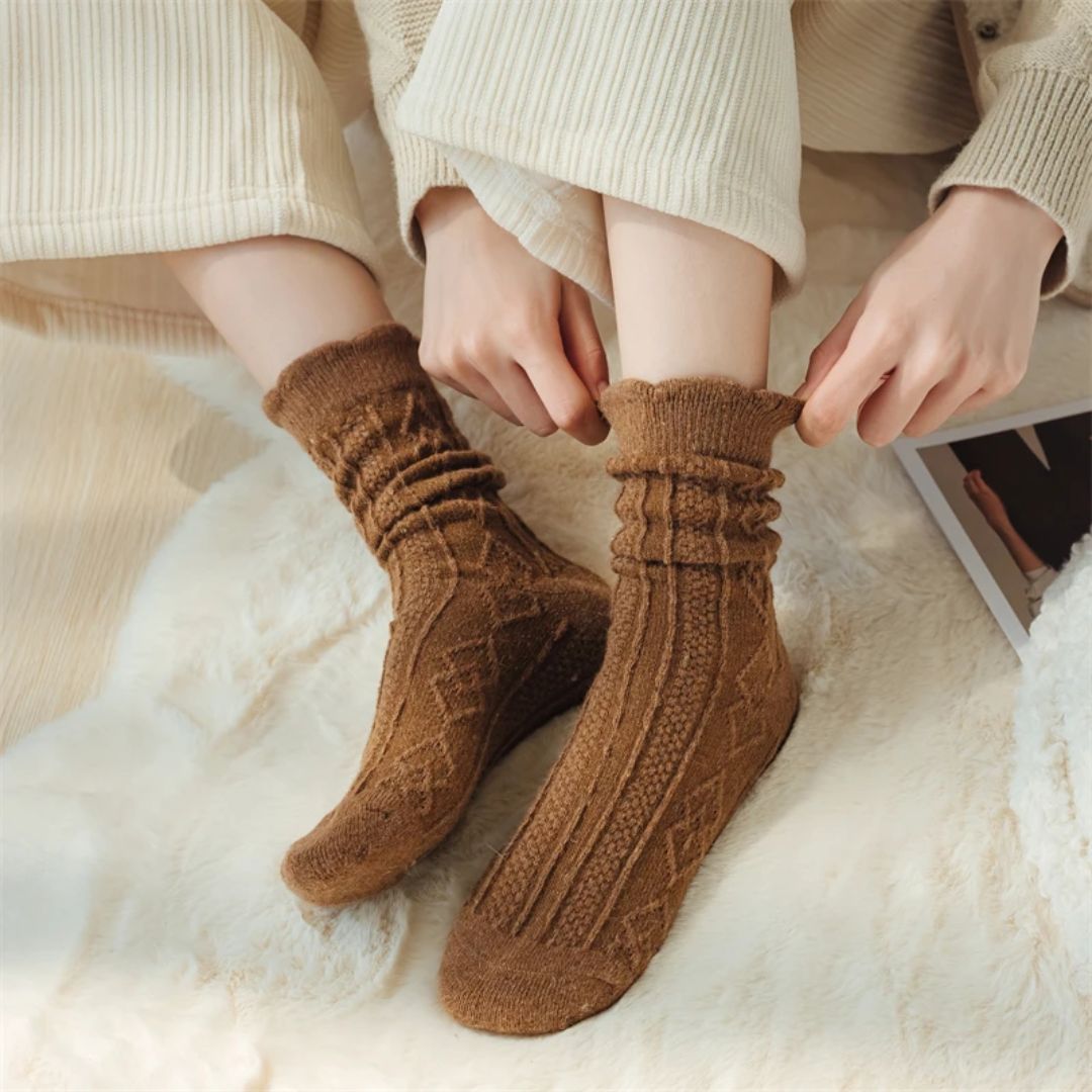 Braune Wollsocken, gestrickt, warm, gemütlich, Damenmode, Herbst-Winter, auf beigem Teppich.